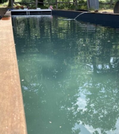 Une piscine container mise en route avec un jet d'eau sur le bord Une piscine container mise en route avec un jet d'eau sur le bord